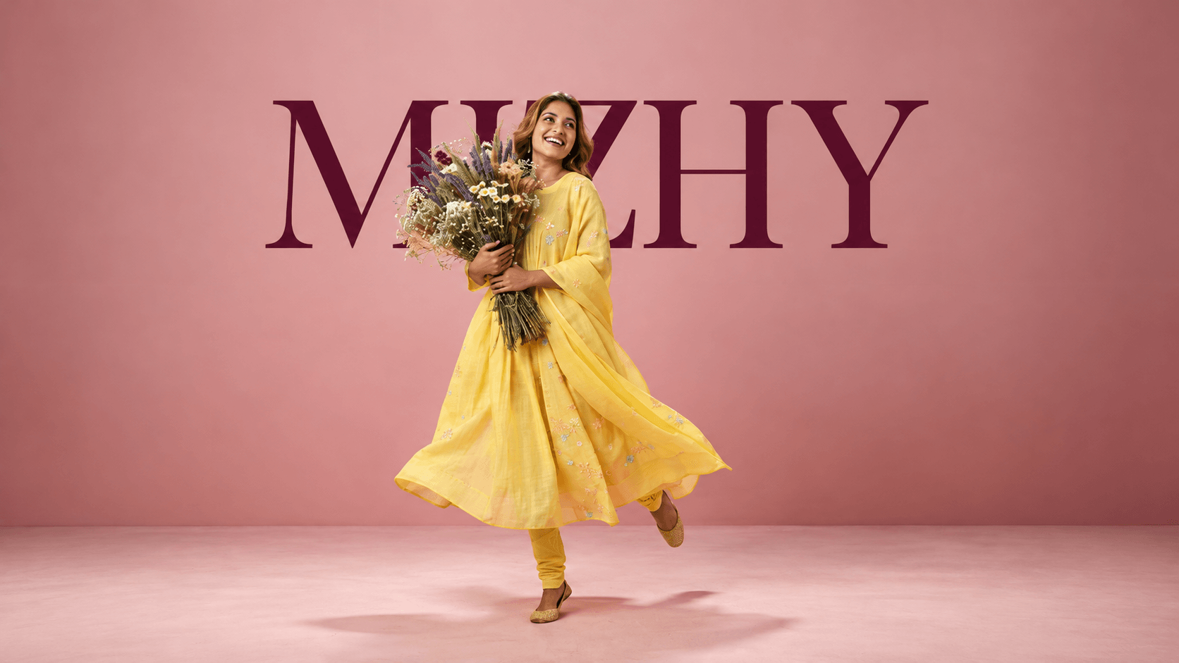 A model in a yellow Mizhy kurta twirling with a wildflower bouquet
